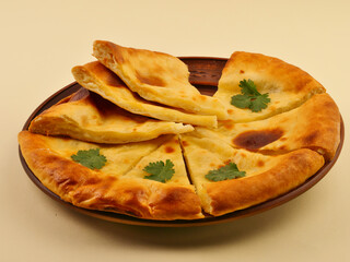 Imereti khachapuri with sauce, cherry tomatoes on a yellow background