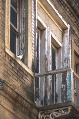 Fototapeta na wymiar Pigeon standing by the windowsill, rustic doors and balcony.