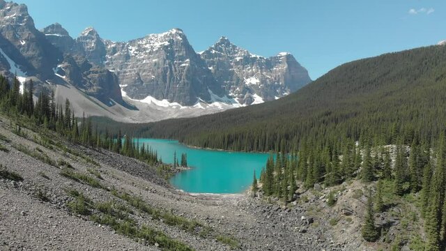 Mountain lake with turquoise water and green trees. Reflection in the water. Beautiful spring landscape with mountains, forest and lake. Aerial View. Drone shot over a beautiful mountain forest lake