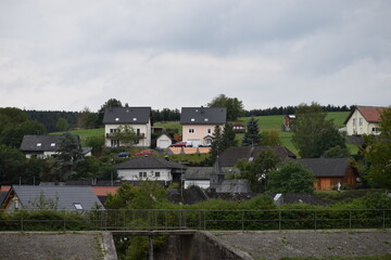 Blick über den Abfluss des Heilbachsee auf das Eifeldorf Gunderath