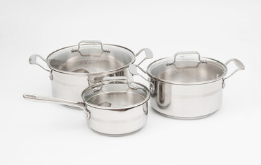 Steel saucepans with lids on white background