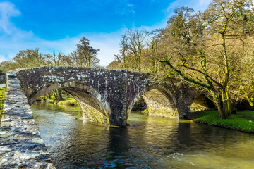 Fototapeta na wymiar A view of the eighteenth century, grade 2 listed bridge at Llawhaden that spans the River Cleddau, Wales