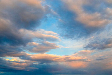Naklejka na ściany i meble Bright cumulus clouds against the blue sky. Sunset sky Natural background.