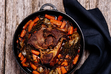 Braised beef brisket big piece with carrots and onion sauce serve in a hot pan