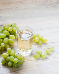 A glass of grape juice with grapes on the table, selective focus.