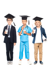 children in graduation caps dressed in costumes of different professions holding glasses with milk isolated on white