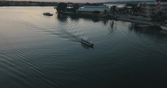Aerial drone shot of a boat on the lake during sunset in Peten, Guatemala