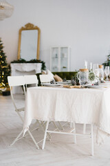 Christmas holiday beautifully set table in a spacious bright dining room or living room in the house