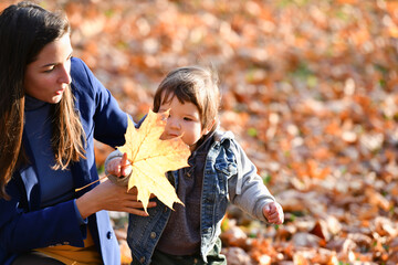 Fototapeta na wymiar Young mother with child spend time in autumn park