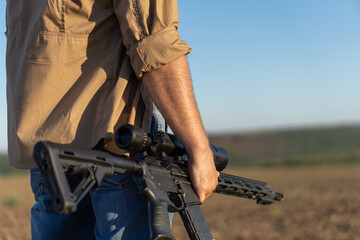 A rifle in a man's hand, close-up. Hunter with a weapon on the hunt against the background of a...