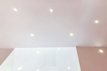 suspended ceiling with halogen spots lamps and drywall construction in empty room in apartment or...