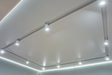 suspended ceiling with halogen spots lamps and drywall construction in empty room in apartment or...
