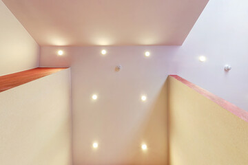 suspended ceiling with halogen spots lamps and drywall construction in empty room in apartment or...