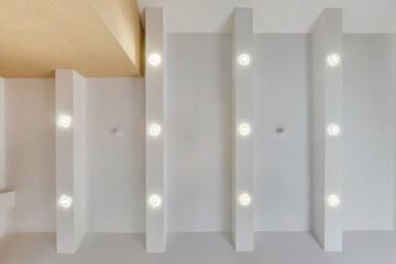 suspended ceiling with halogen spots lamps and drywall construction in empty room in apartment or...