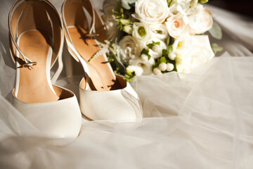 wedding shoes with a bouquet of white roses