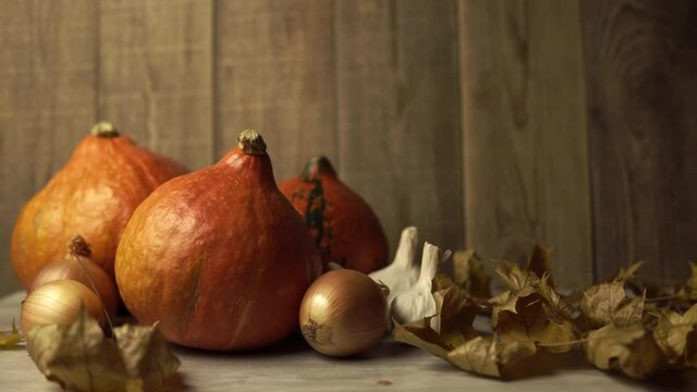 Still life of autumn vegetables on a wooden background. Theme of the fall ecology harvest and thanksgiving day holiday. Camera pans on a composition of a group of ripe veggie produce.