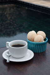Simple breakfast with coffee and cheese bread near a swimming pool