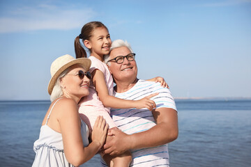 Little girl with grandparents spending time together  near sea