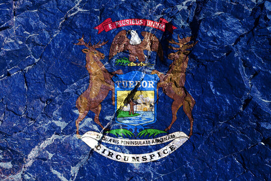 State flag of USA, Michigan is applied to mountain cliff in form of coat of arms with rising sun over lake and man standing on peninsula with pistol in hand. By an elk, and a wapiti, and a bald eagle.