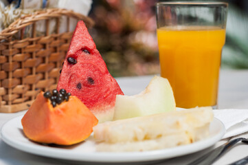 Healthy and fresh breakfast with fruits, like watermelon, papaya, melon, and a delicious orange juice