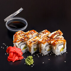 Traditional delicious fresh Unagi sushi roll set on a black background with reflection.