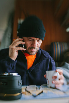 Man Checking a Map While Talking by Phone inside a Mobile Home