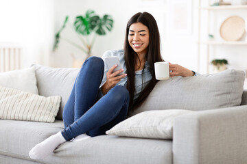 Weekend Relax. Happy Asian Girl Using Smartphone And Having Morning Coffee