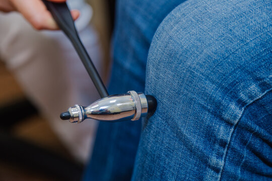 Woman neurologist examines a patient with a hammer in a private clinic