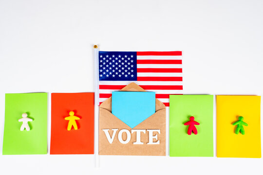Election of the President of the United States. Voting in the American Presidential election. Flatlay theme of elections in America. Colorful little men, USA flag and a ballot paper.