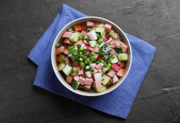 Delicious cold okroshka with kvass on black table, top view. Traditional Russian summer soup
