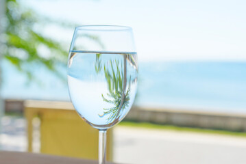 a glass of clear and pure water on the background of the sea