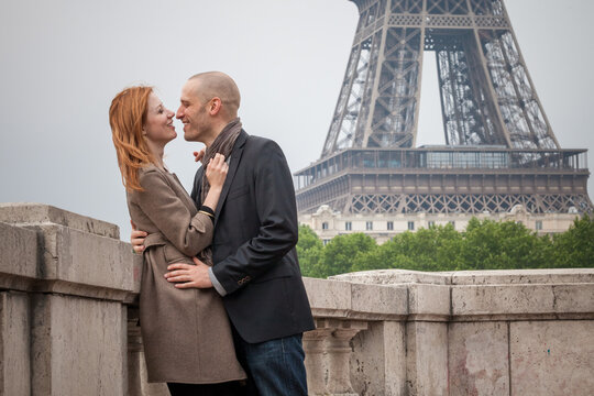 Romantic couple in Paris embrace near the Eiffel Tower