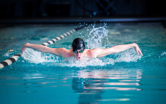 Male Swimmer Racing Toward Finish Performing Butterfly Stroke