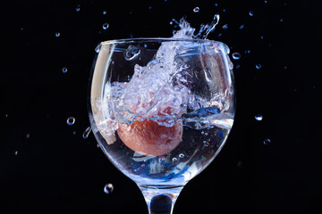 glass of water with fruit inside and splashing water