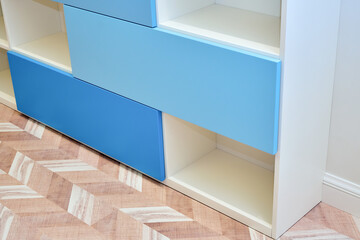 Modern white bookcase with blue doors close-up