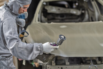 An employee of the paint shop prepares the car body for painting