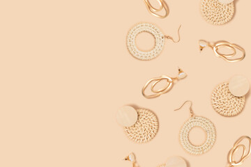 Earrings pattern frame on a beige background. Vintage accessories layout with copy space.