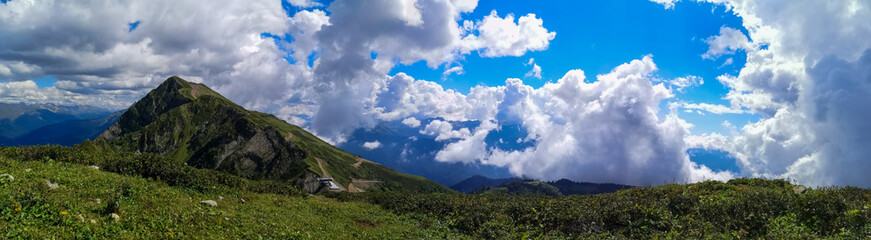 Obraz premium Panoramic view of the mountain top and blue sky with white clouds
