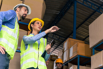 Boss and secretary with warehouse worker working in warehouse inspecting goods and package