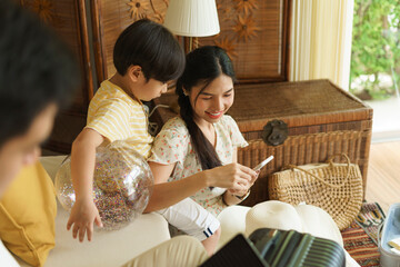 Asian mother and father using smartphone together at home.