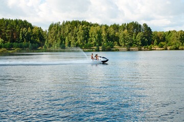 Jetski with people floating on the pond in the countryside in summer.