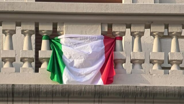 close up of Italian flag at the balcony in Italy for covid-19 dead memorial and mourning during quarantine lockdown.