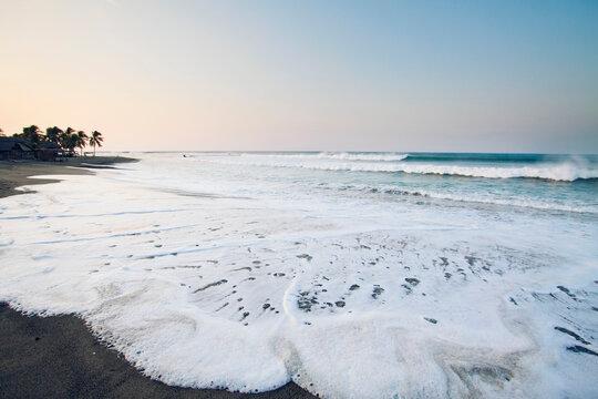 Waves washing over the sand at high tide.