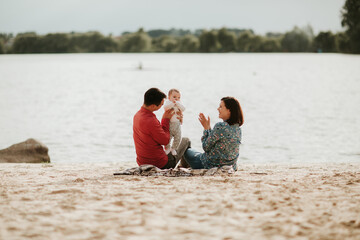 happy family resting by the lake. family with a small child