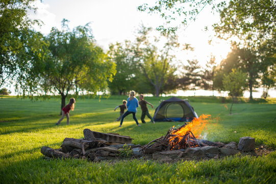 Backyard Camp Out: Children Play Tag with Campfire in Foreground