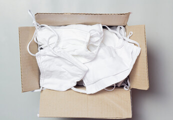 A medical mask used to prevent corona infection and is being packaged in a pre-packaged box for flat lay view.
