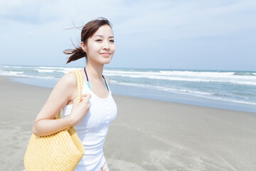 Fototapeta na wymiar 砂浜を散歩する女性