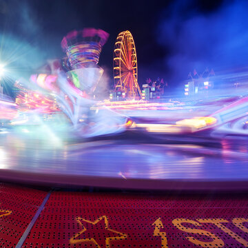 Illuminated motion blured carnival ride at night