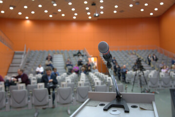 conference hall with microphone on foreground