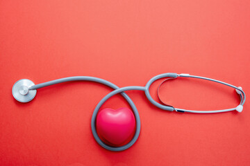 Stethoscope on red background. Health checkup cardio diagnosis concept.